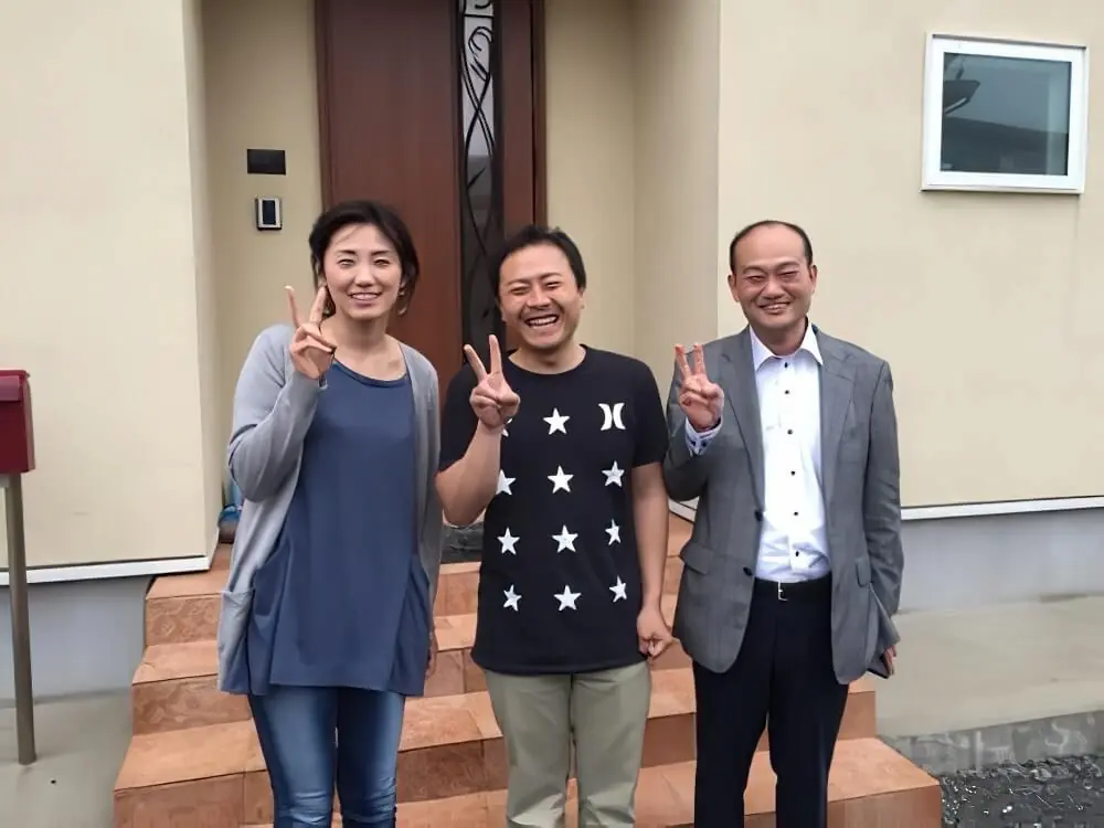 完成した住まいの玄関前でお客様と代表が記念撮影
