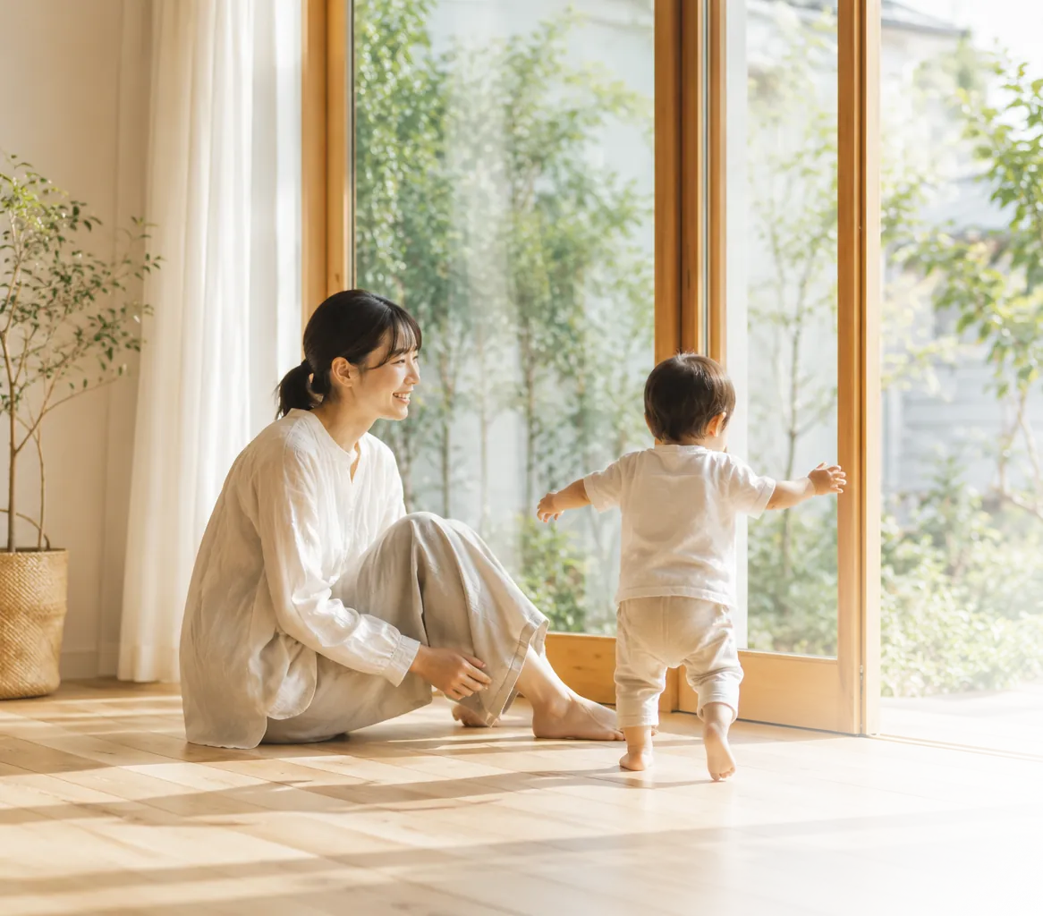 自然光が入る窓辺で親子が安心して過ごす自然素材の住まい