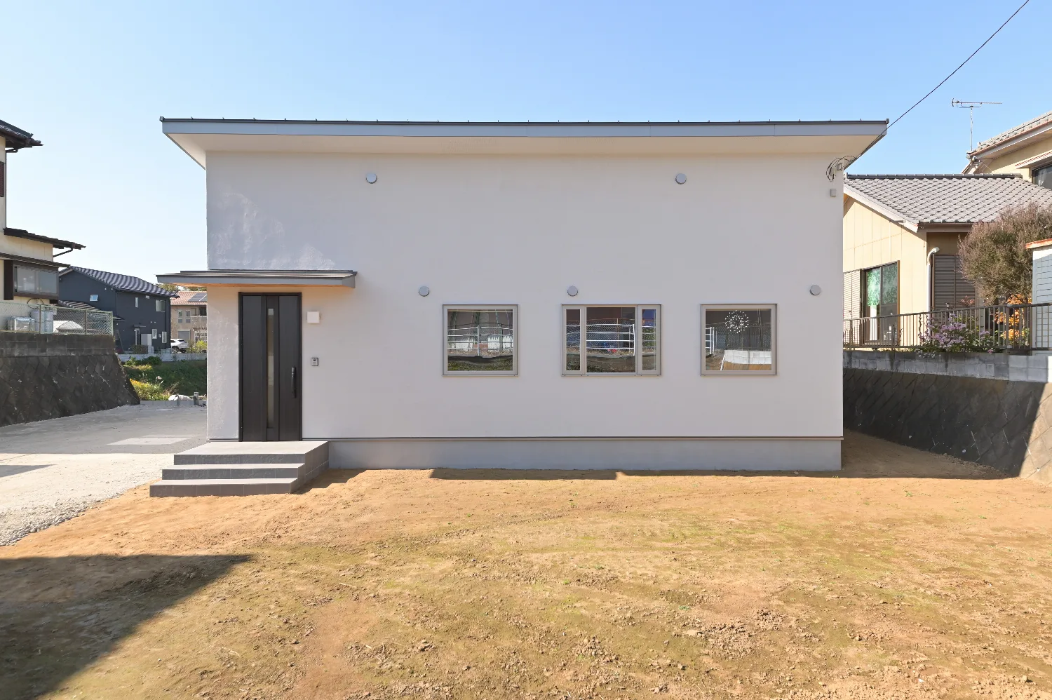 木格子が風景を編む。ウッドデッキとつながる白い平屋