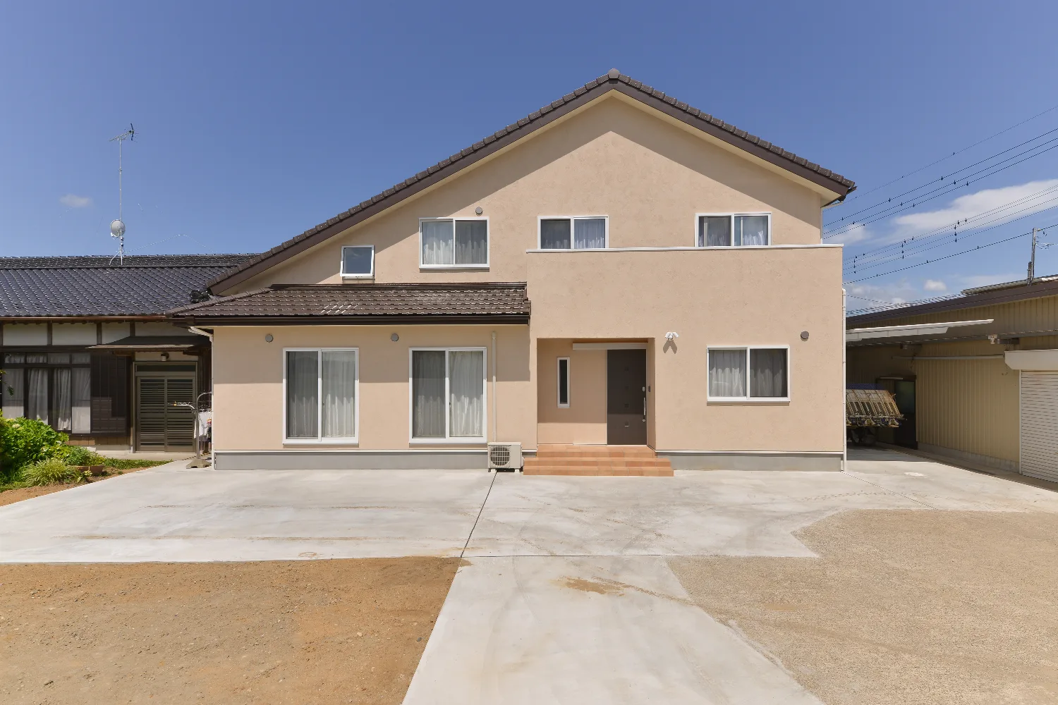 太い梁とオレンジのキッチン。和室が並ぶ、大屋根の家