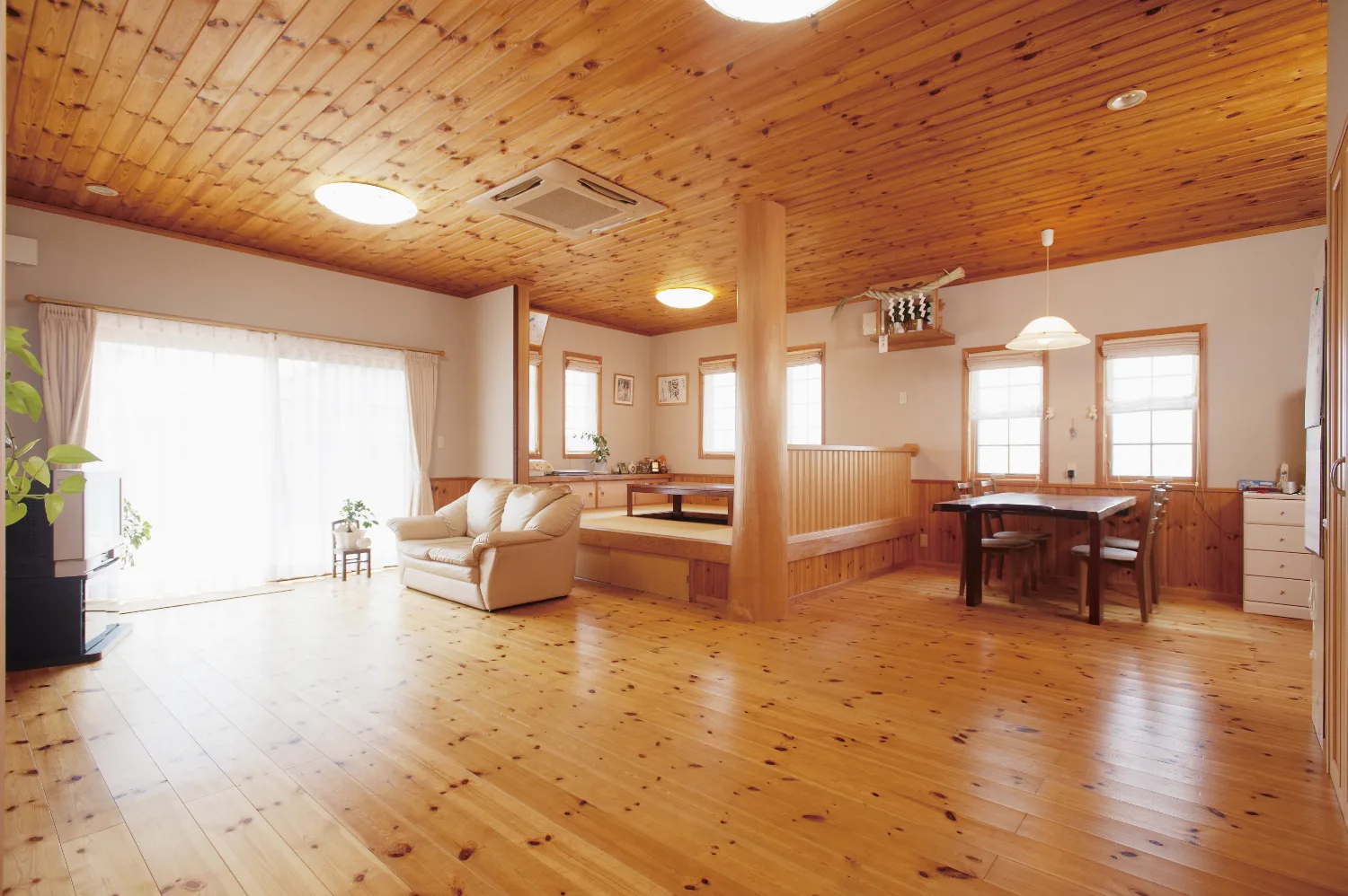 丸太手すりの大きなデッキと、パインに包まれた平屋