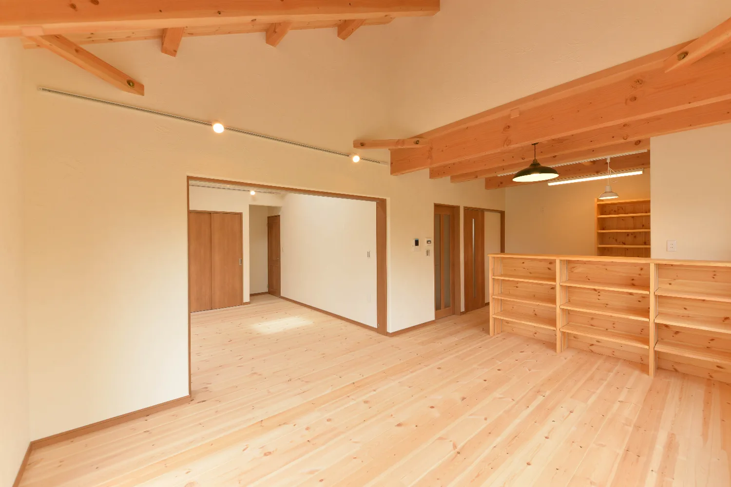 天窓から光が降る、勾配天井の平屋。壁一面の造作本棚