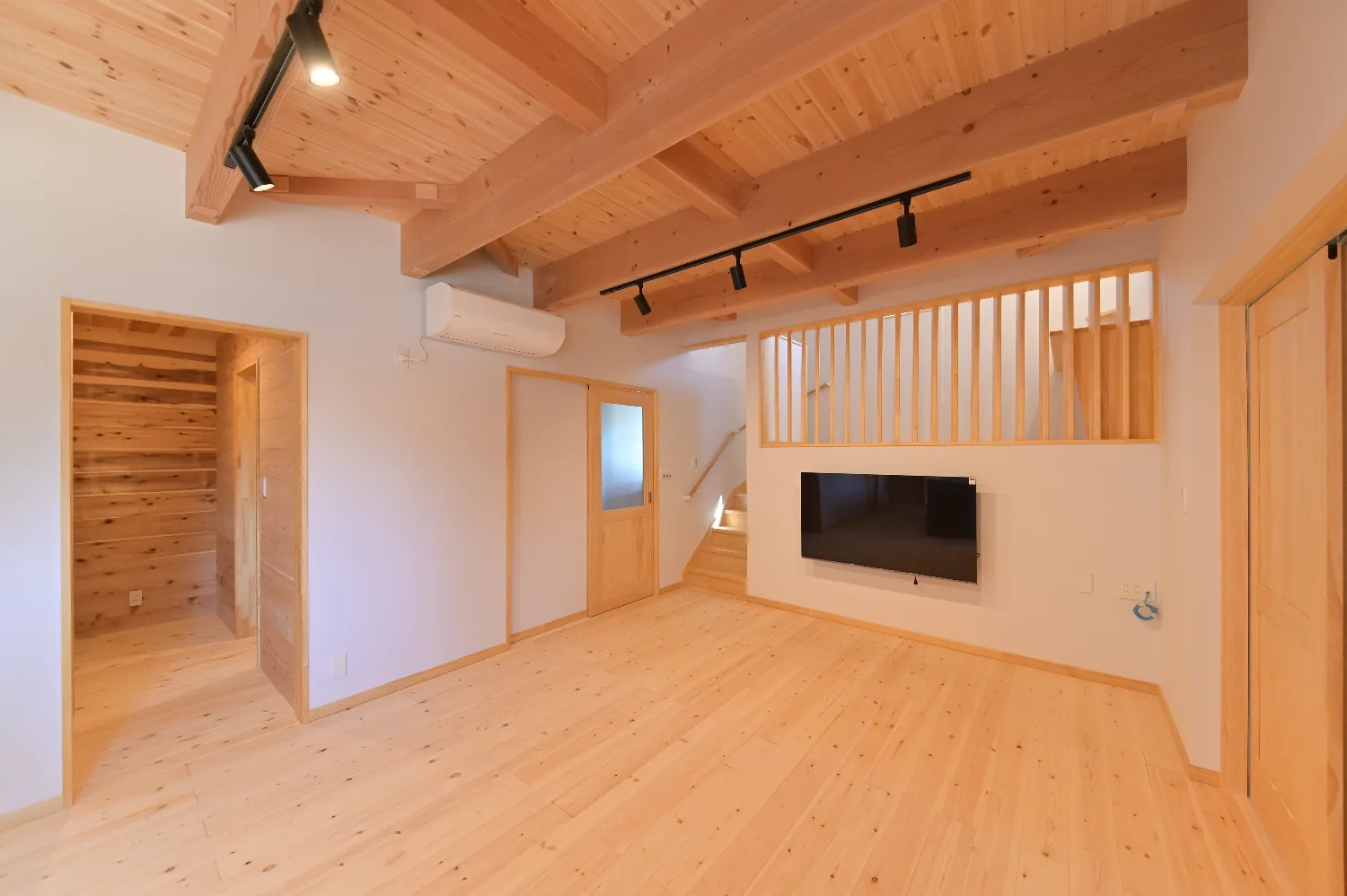 登り梁を見上げる平屋。ウッドデッキと太陽光を備えた住まい
