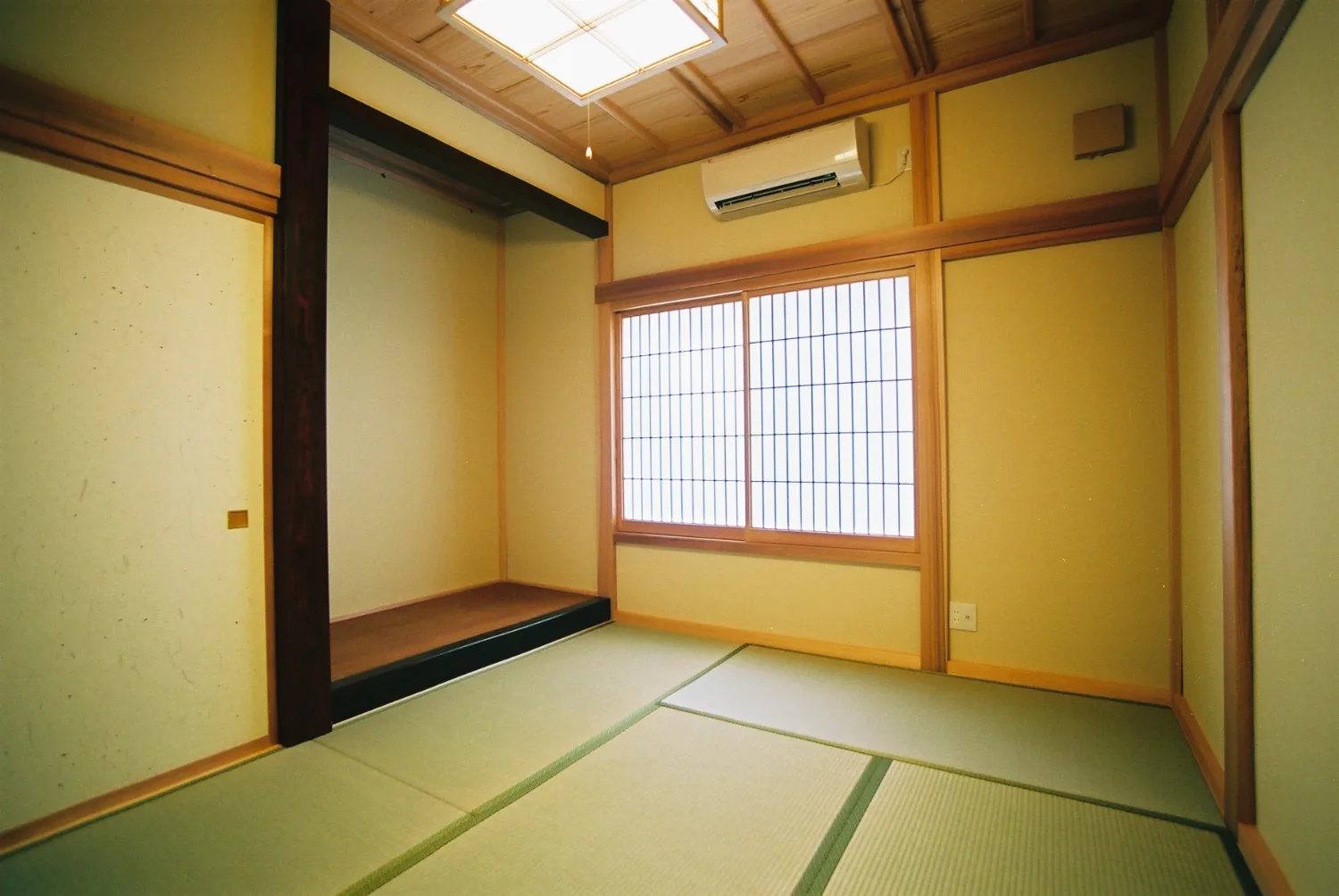 田んぼに浮かぶ、赤瓦の南欧邸宅。石張りの腰壁とウッドデッキ