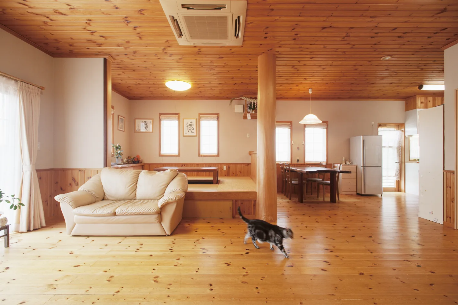 丸太手すりの大きなデッキと、パインに包まれた平屋