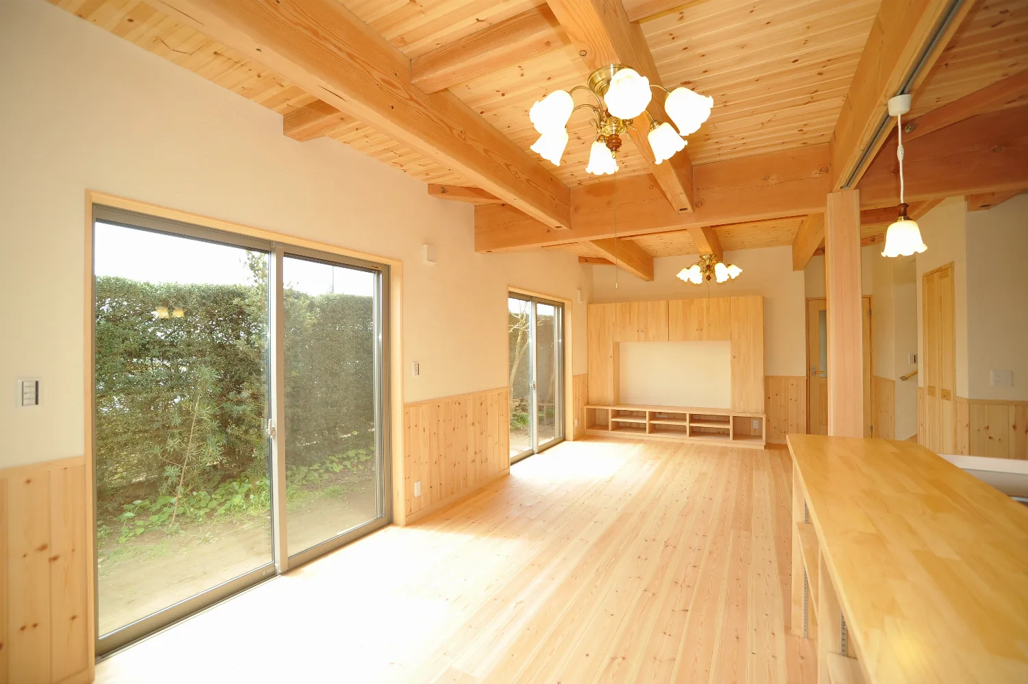 格子に組んだ梁と、壁一面の造作収納。パインに包まれた住まい