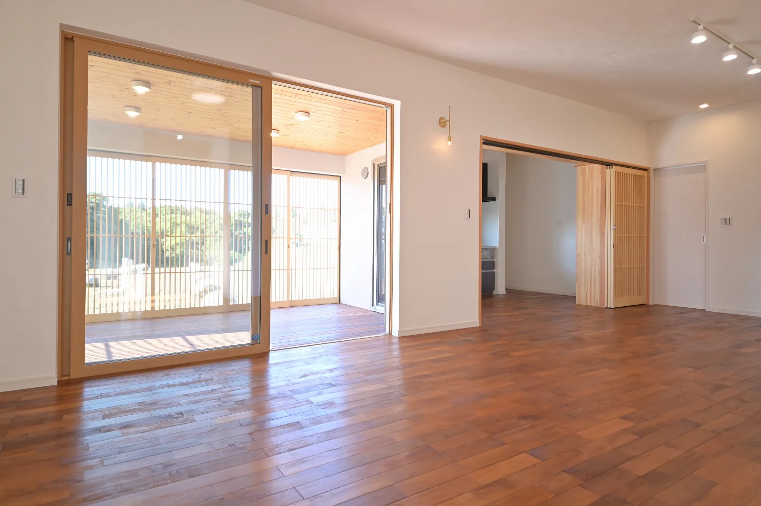 木格子が風景を編む。ウッドデッキとつながる白い平屋