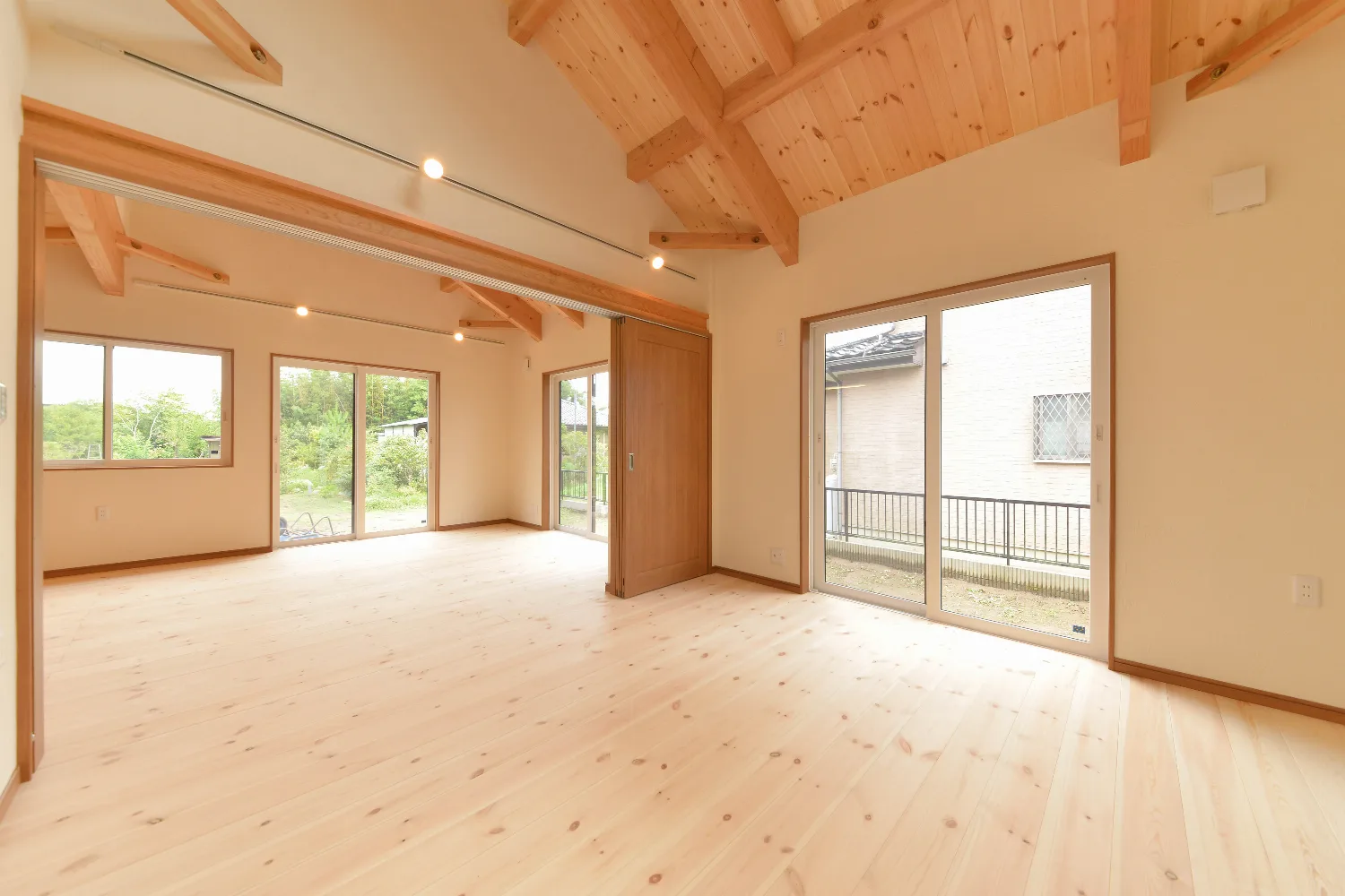 天窓から光が降る、勾配天井の平屋。壁一面の造作本棚