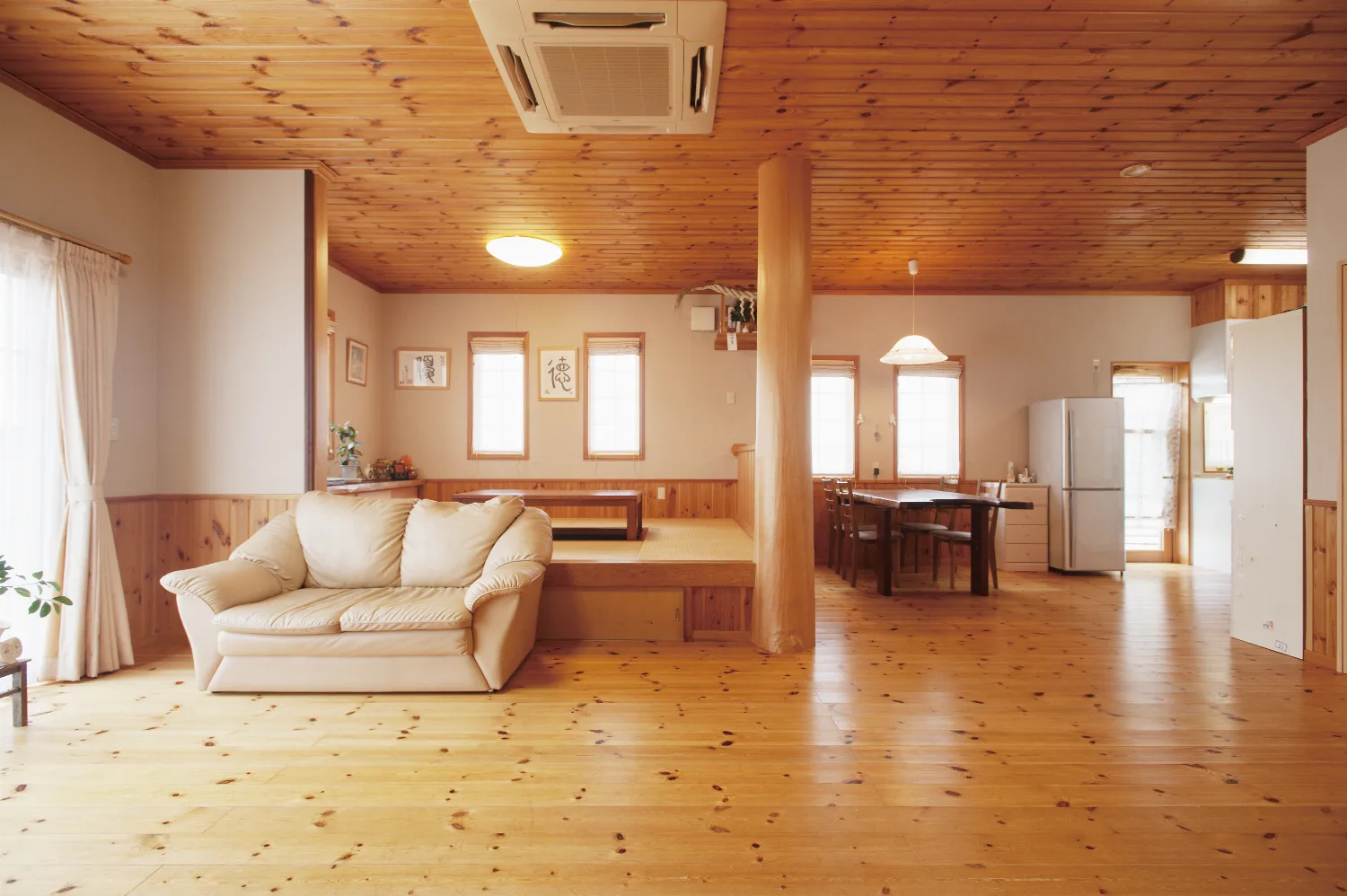 丸太手すりの大きなデッキと、パインに包まれた平屋