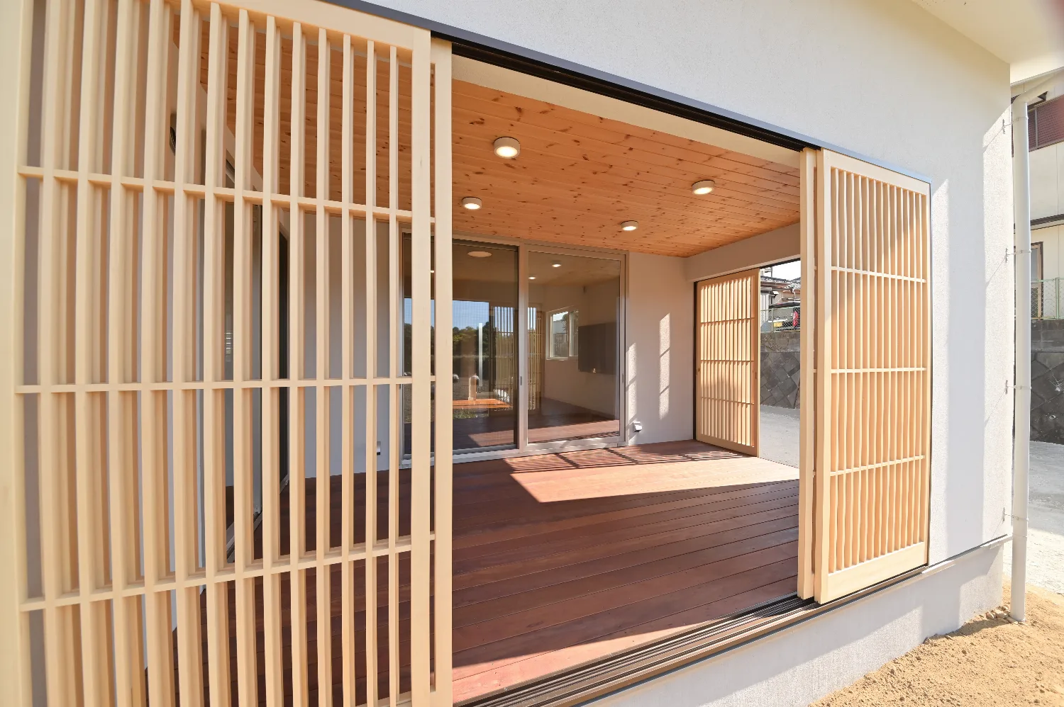 木格子が風景を編む。ウッドデッキとつながる白い平屋
