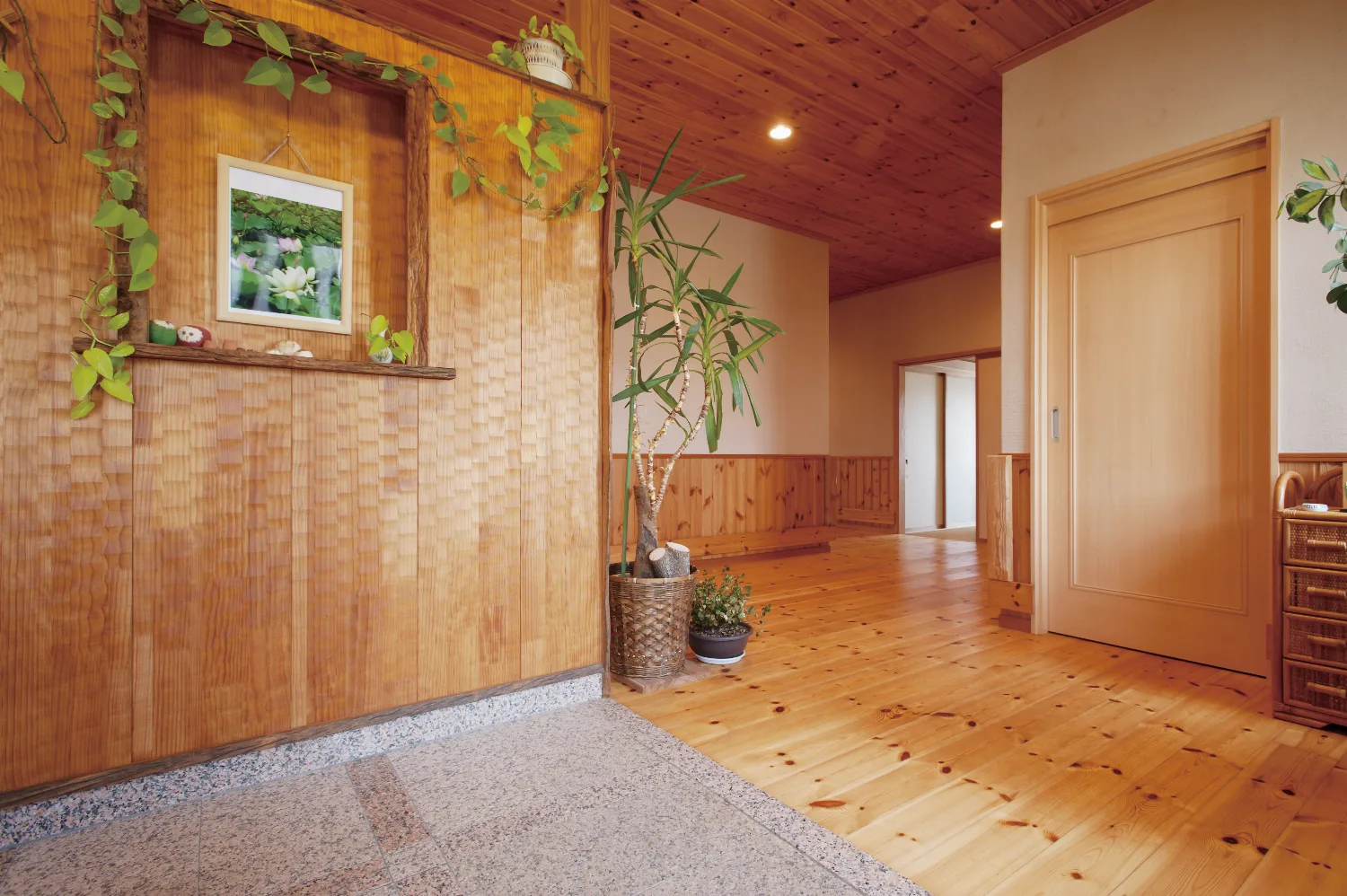 丸太手すりの大きなデッキと、パインに包まれた平屋