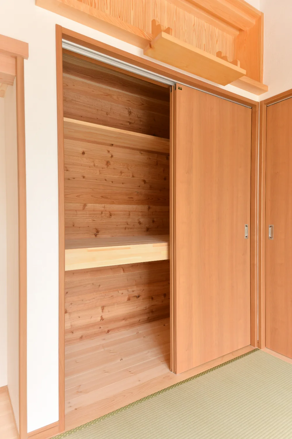 太い梁とオレンジのキッチン。和室が並ぶ、大屋根の家